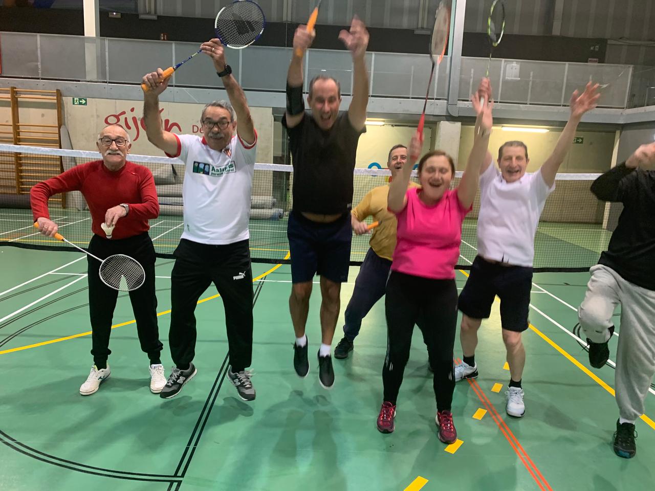 Jugadores de badMMinton project saltan con las raquetas en alto celebrando en la pista de bádminton